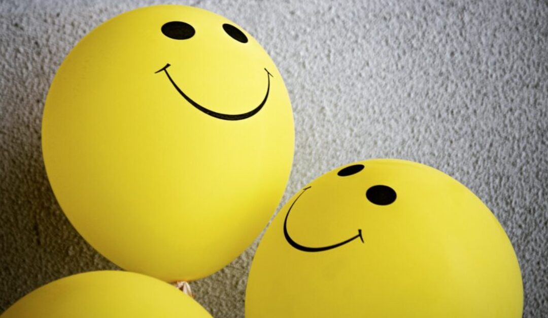 Three smiley face balloons